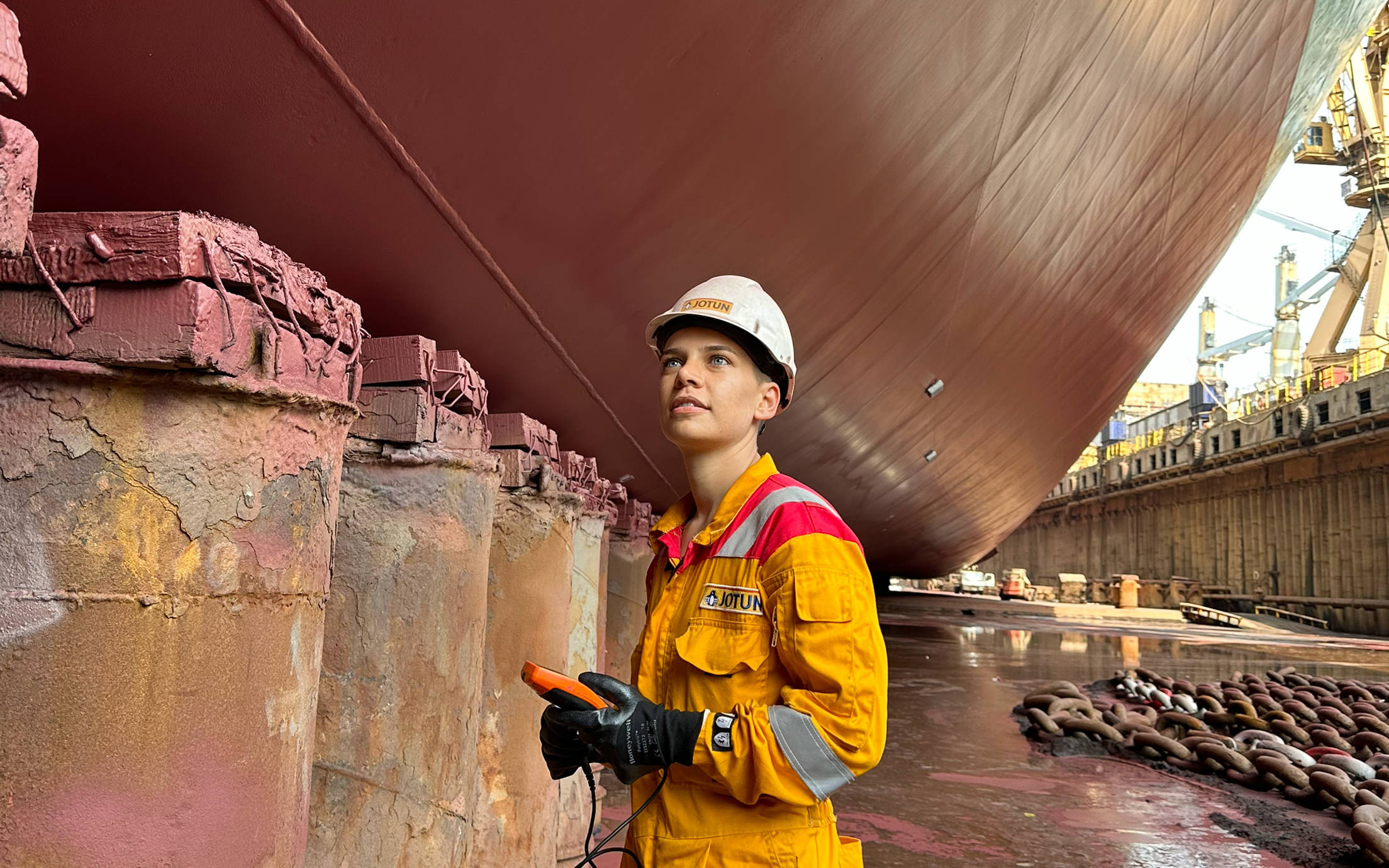 Nilay Yilmaz standing in the dock looking up on a ship hull